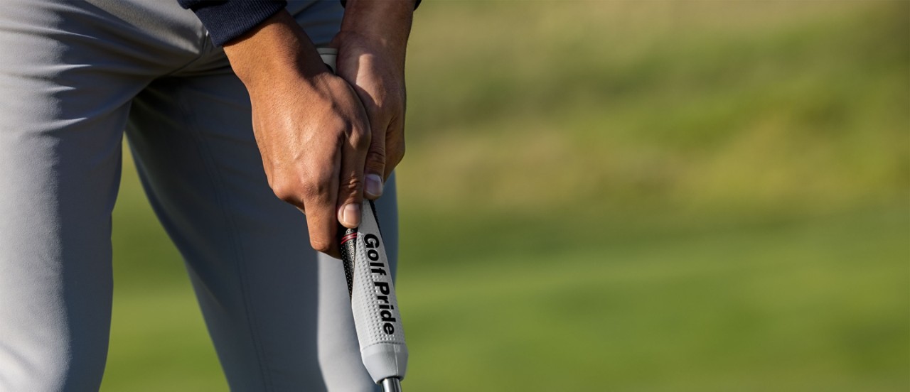 golfer putting with reverse taper grip on a green